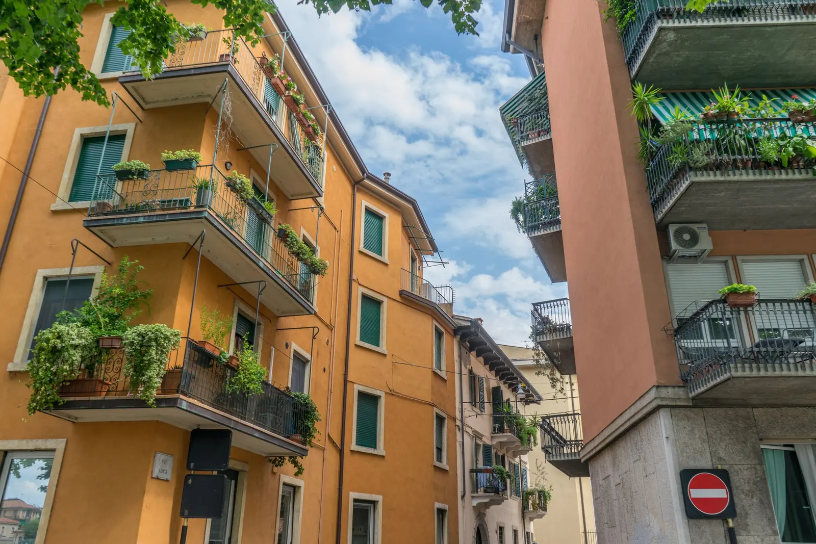 Condomini di Verona con i balconi pieni di piante, visti dal basso