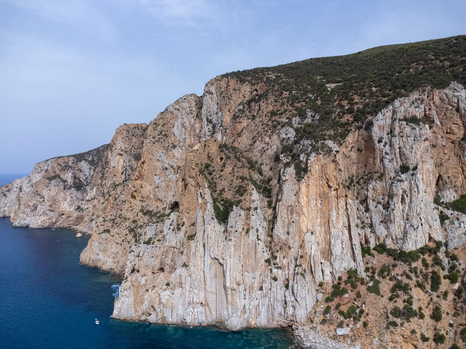 Una scogliera chiara sul mare blu della Sardegna, vista dall'alto