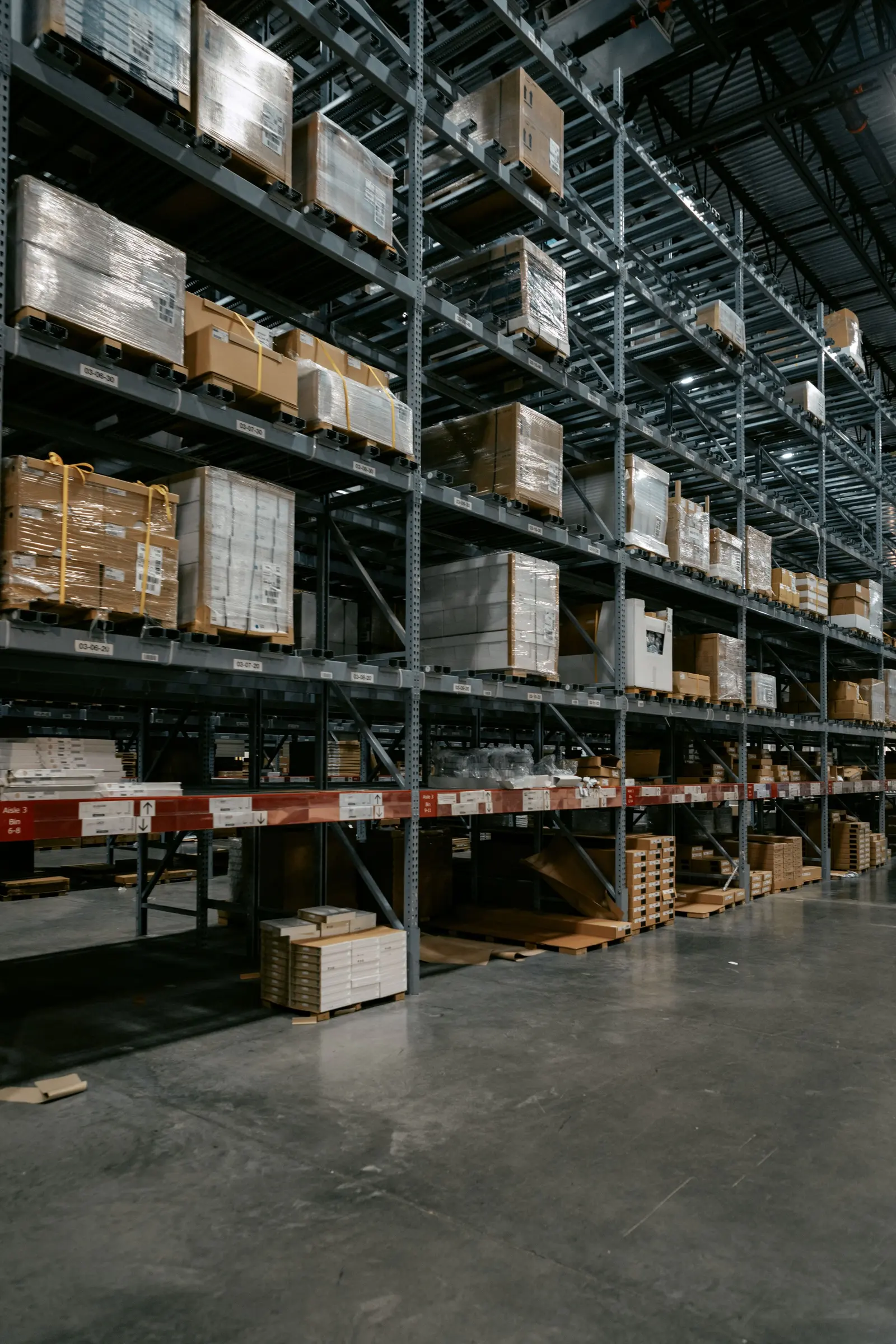 Magazzino con scaffalature alte e cartoni su pallet