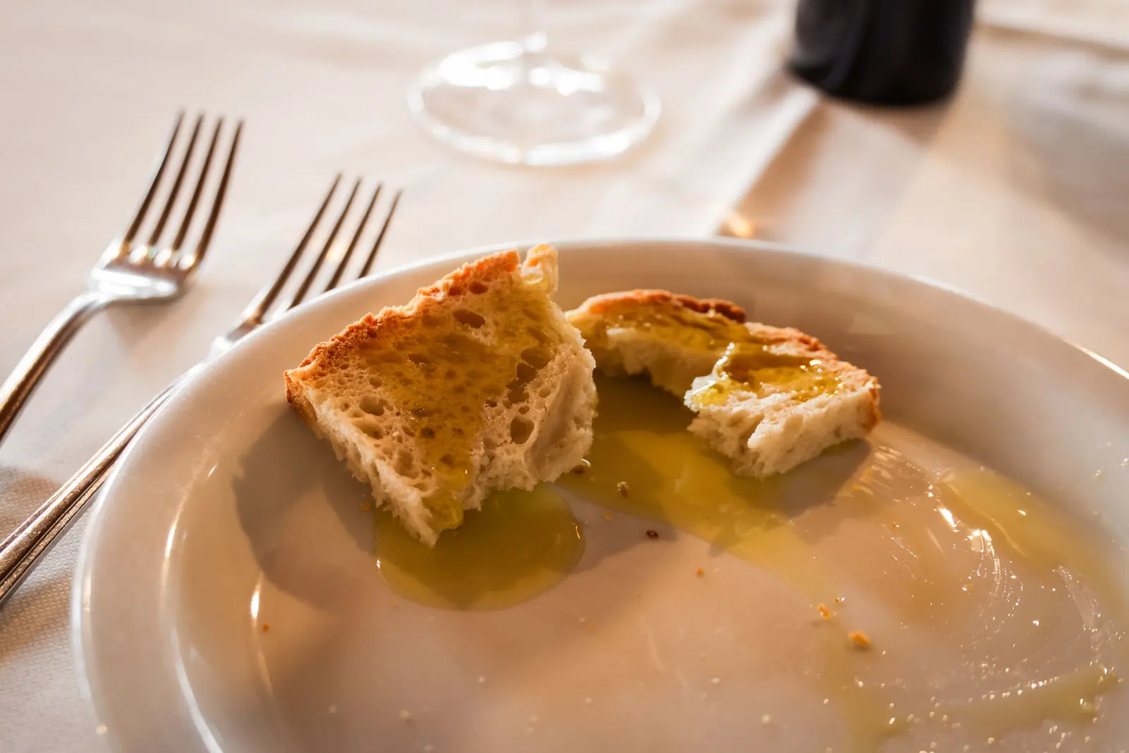 Pane intinto nell'olio su un piatto bianco, al ristorante
