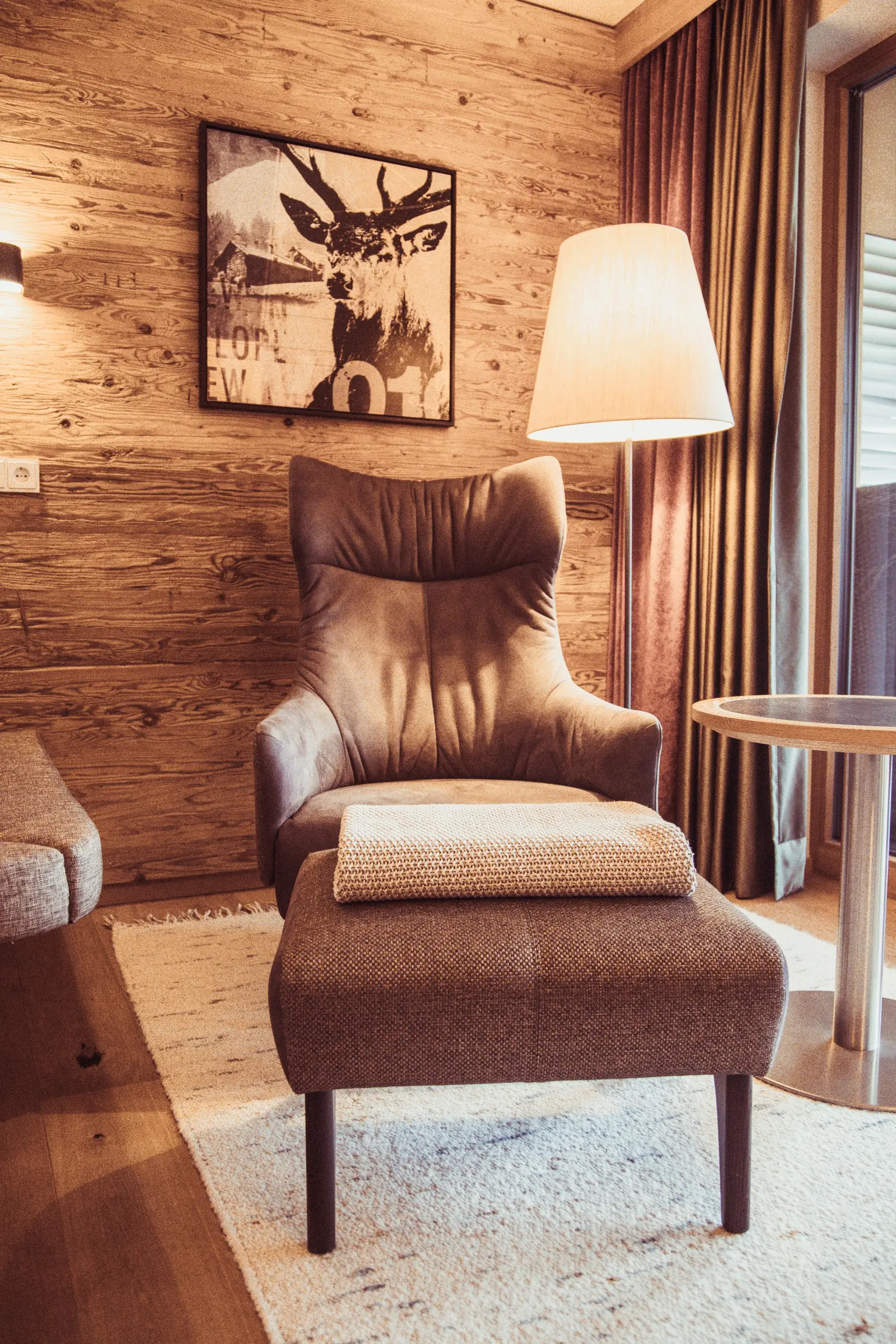 Angolo di camera con poltrona di cuoio, lampada e pareti di legno