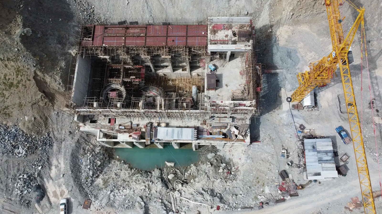 Cantiere visto dall'alto, con una gru gialla, uno scavo e i baraccamenti