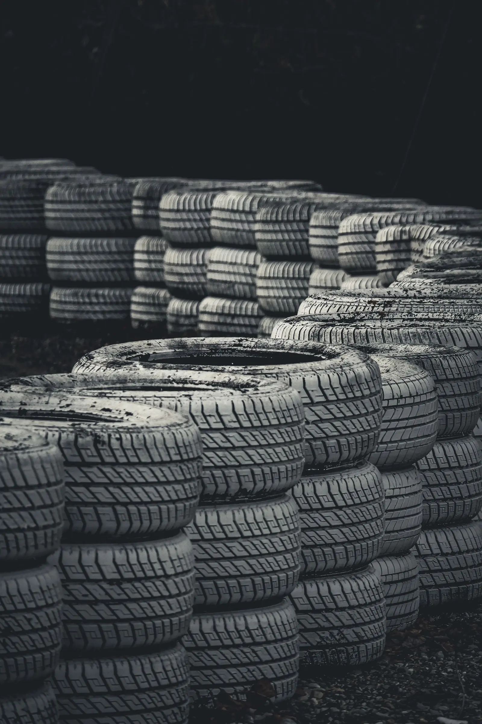 Muro di gomme dipinte di bianco a bordo pista, al buio
