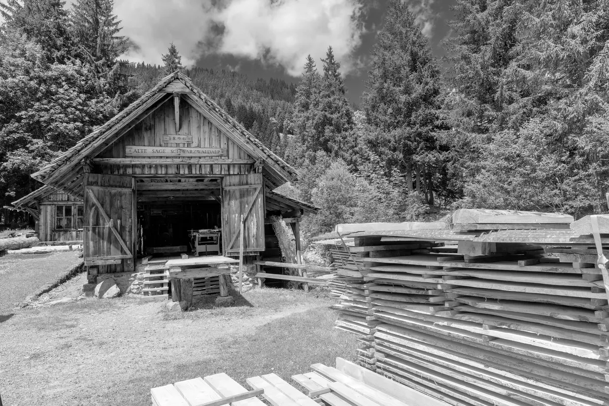 Vecchia segheria in legno con le tavole accatastate, in bianco e nero