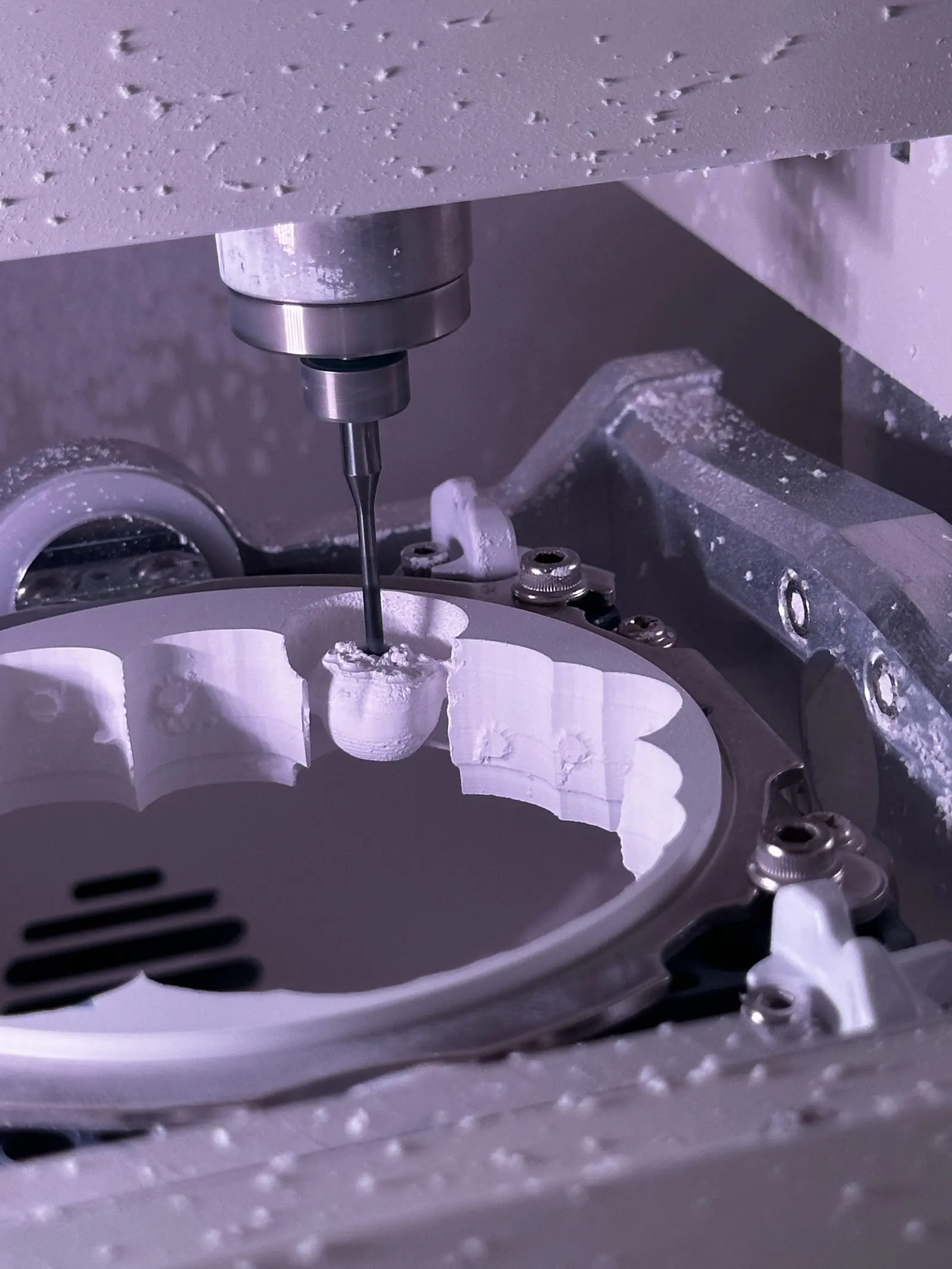 Fresatrice che lavora un restauro in ceramica dentro la camera di fresatura