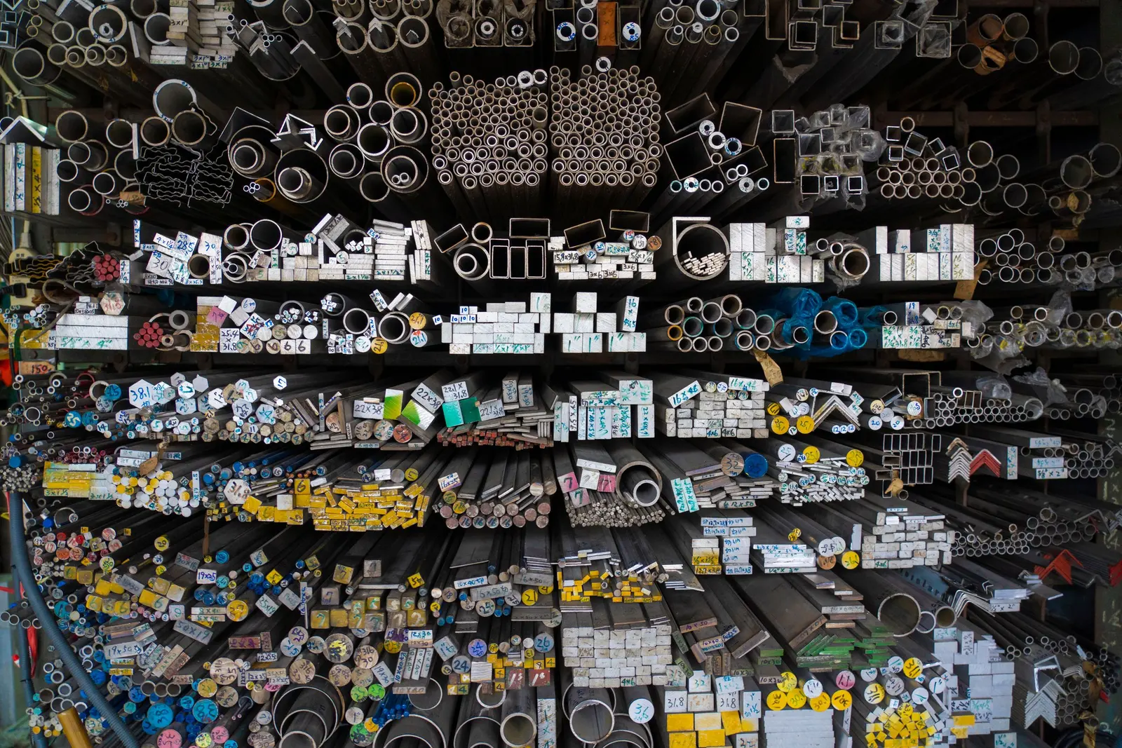 Uno scaffale pieno di tubi e profilati metallici
