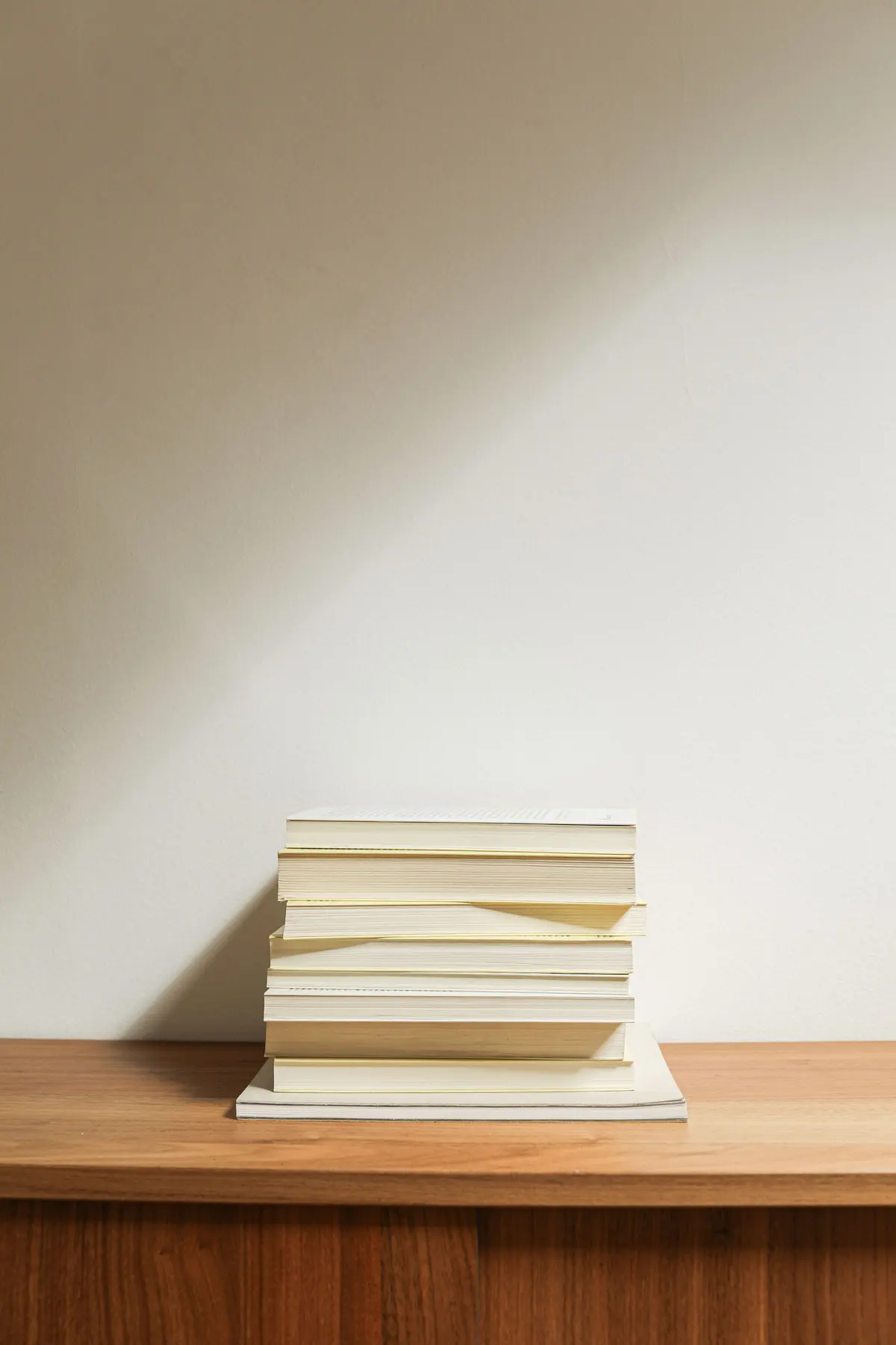 Pila di libri con le pagine bianche su un mobile di legno