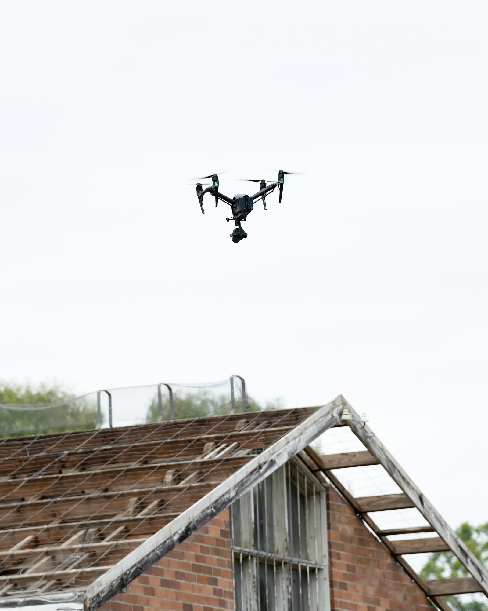 Un drone con la telecamera in volo sopra il tetto di un vecchio edificio in mattoni