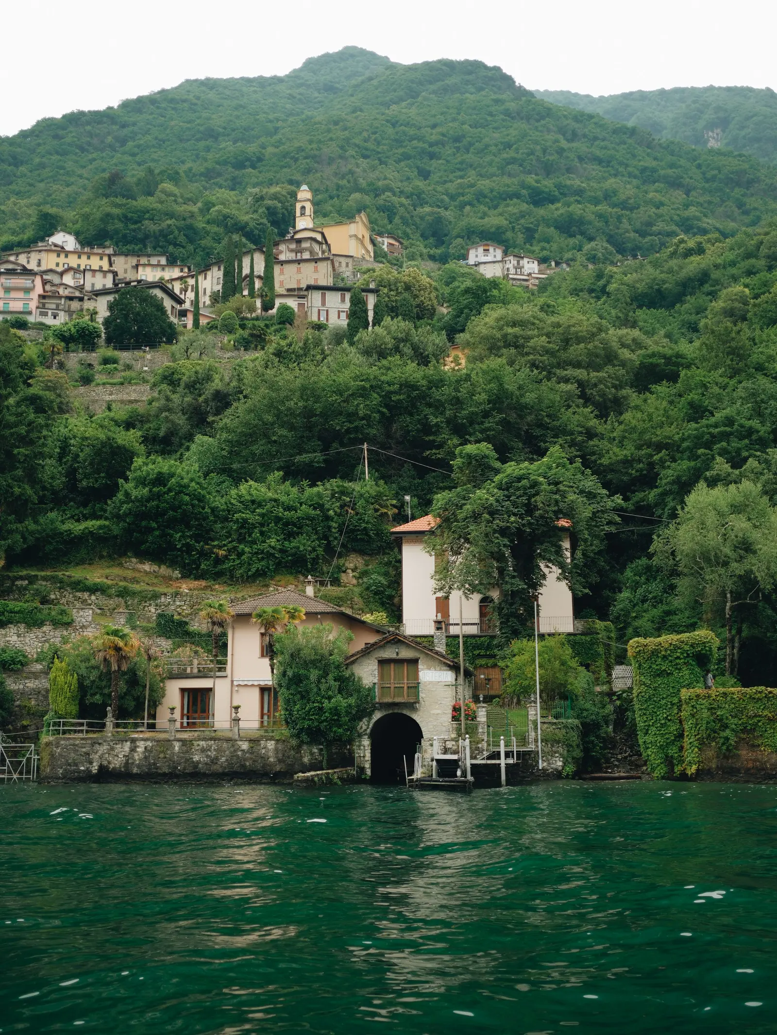 Casa con darsena e torretta sulla riva, tra il verde fitto
