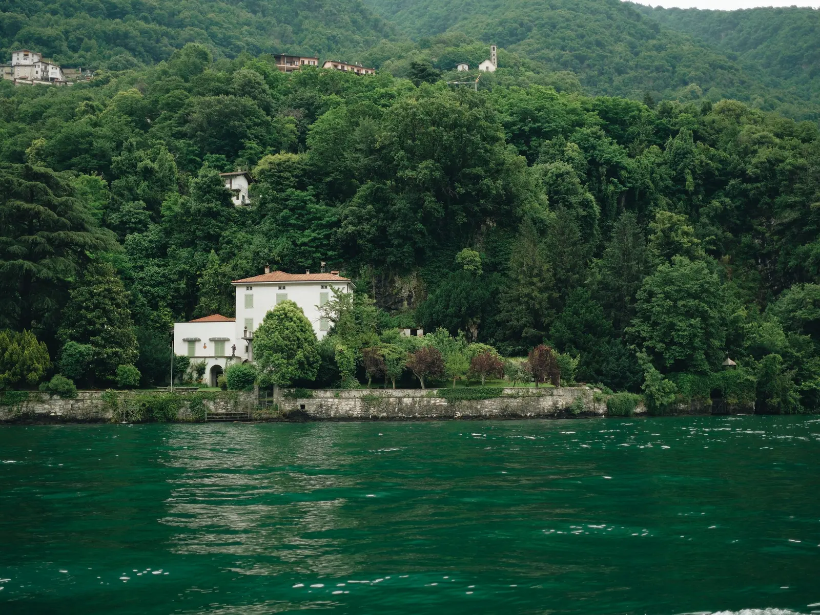 Villa bianca tra gli alberi sulla riva del lago