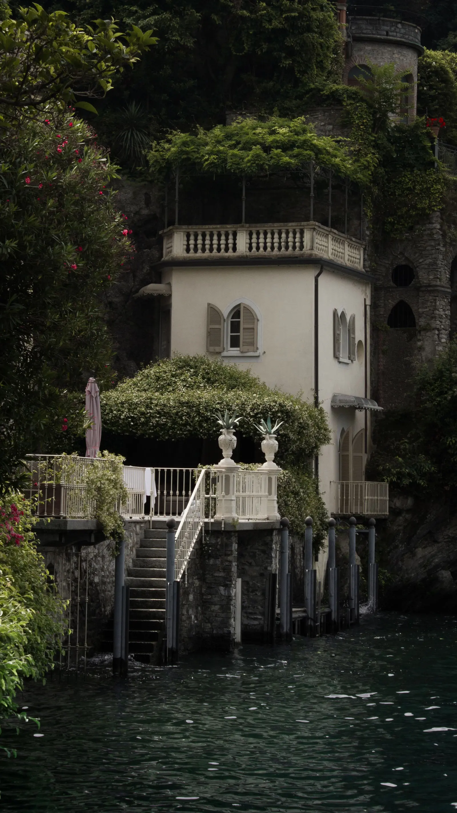 Villa bianca con la scalinata che scende fino all'acqua, tra gli alberi