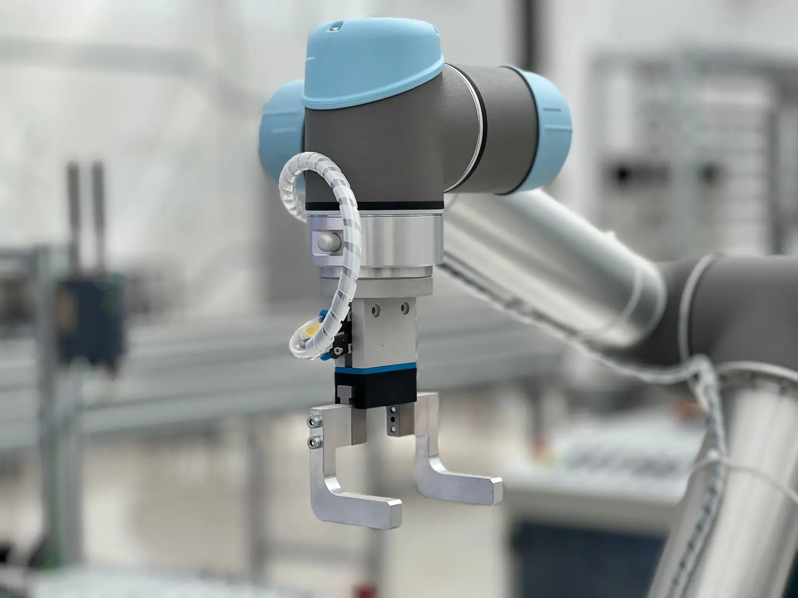 Robot collaborativo con pinza a due dita in un reparto di assemblaggio