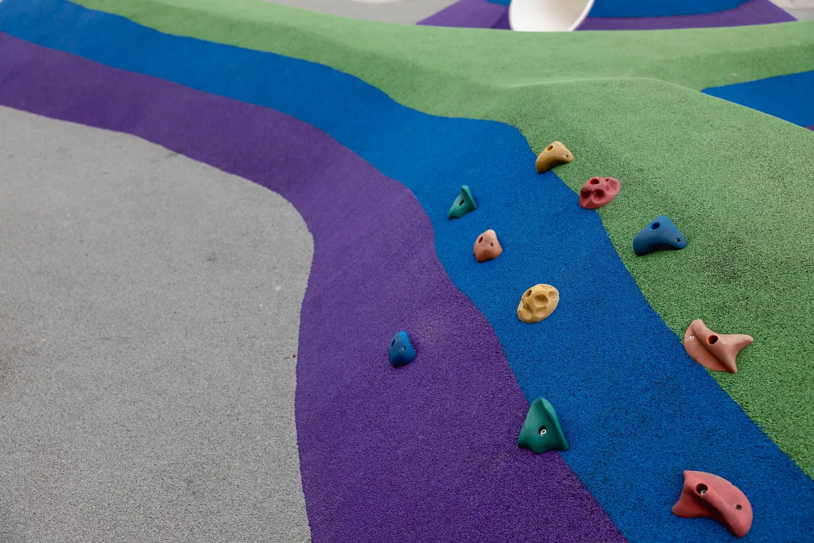 Collinette di gomma colata viola, blu e verde con appigli colorati per arrampicarsi