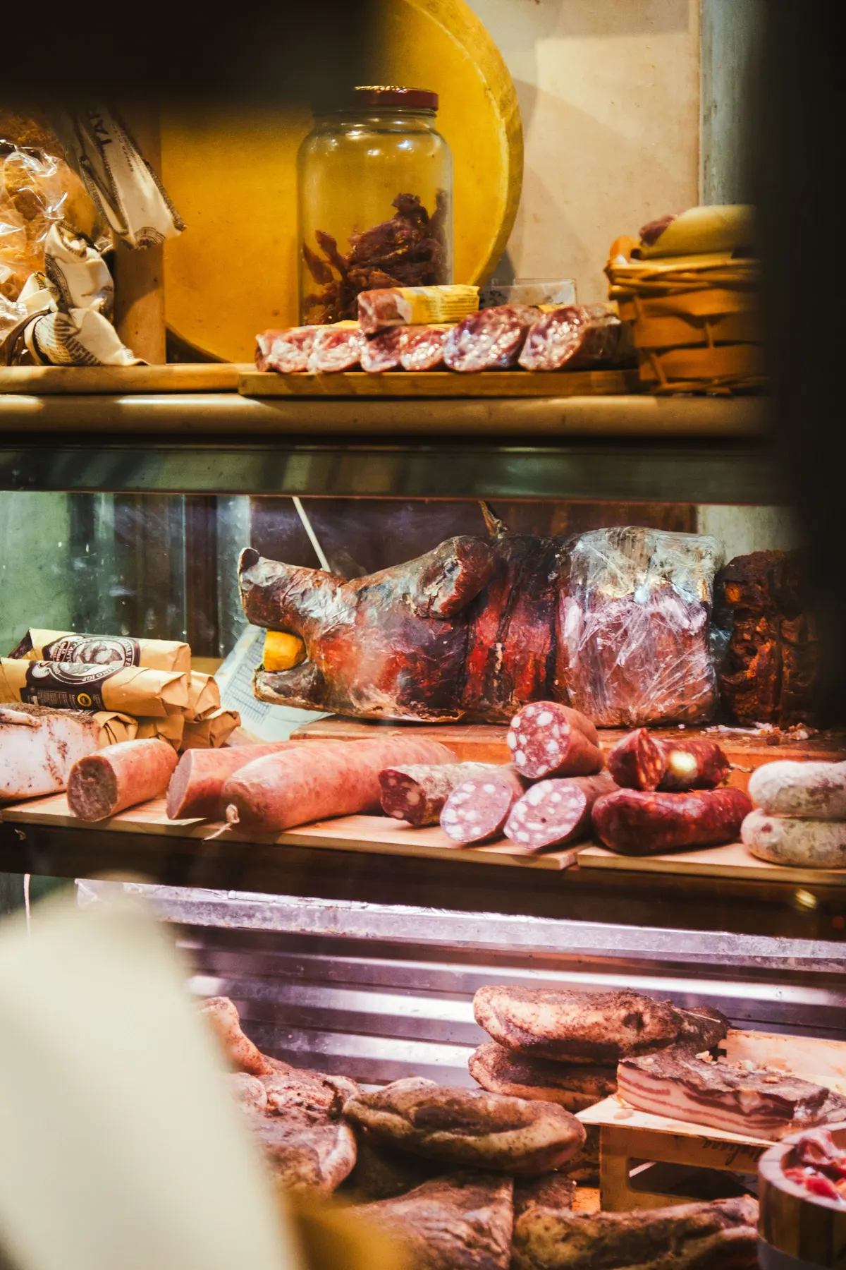 Il banco di una gastronomia con salumi e formaggi in vetrina