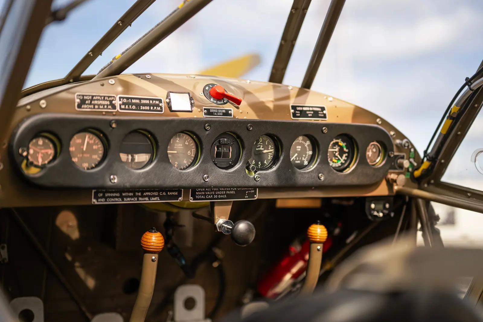 Cruscotto di un aereo d'epoca con una fila di strumenti a lancette su un pannello nero