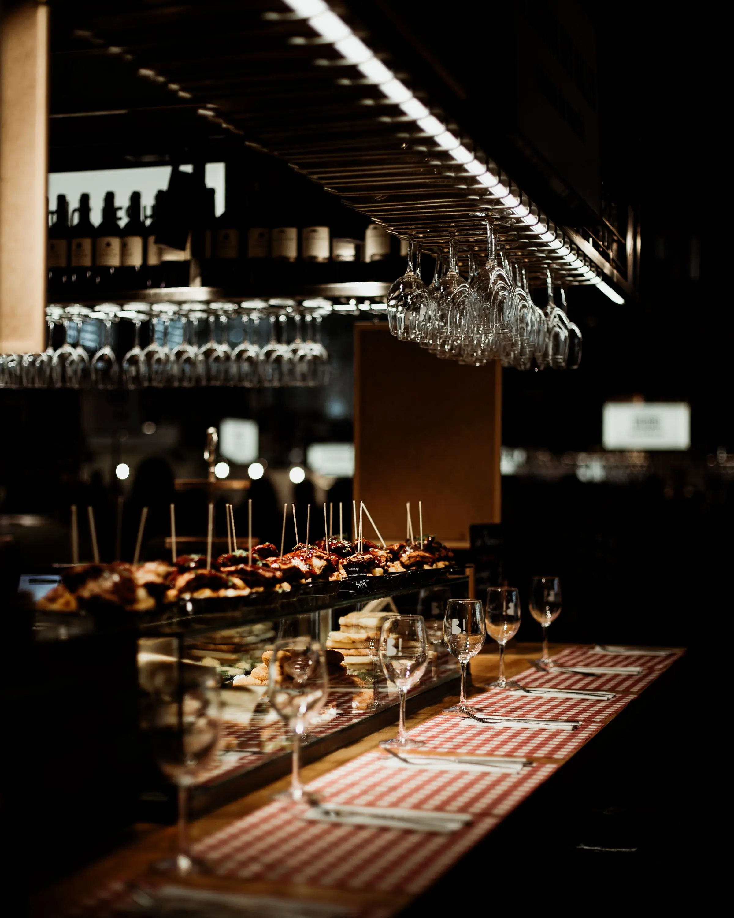 Banco scuro da degustazione con bicchieri e luce radente