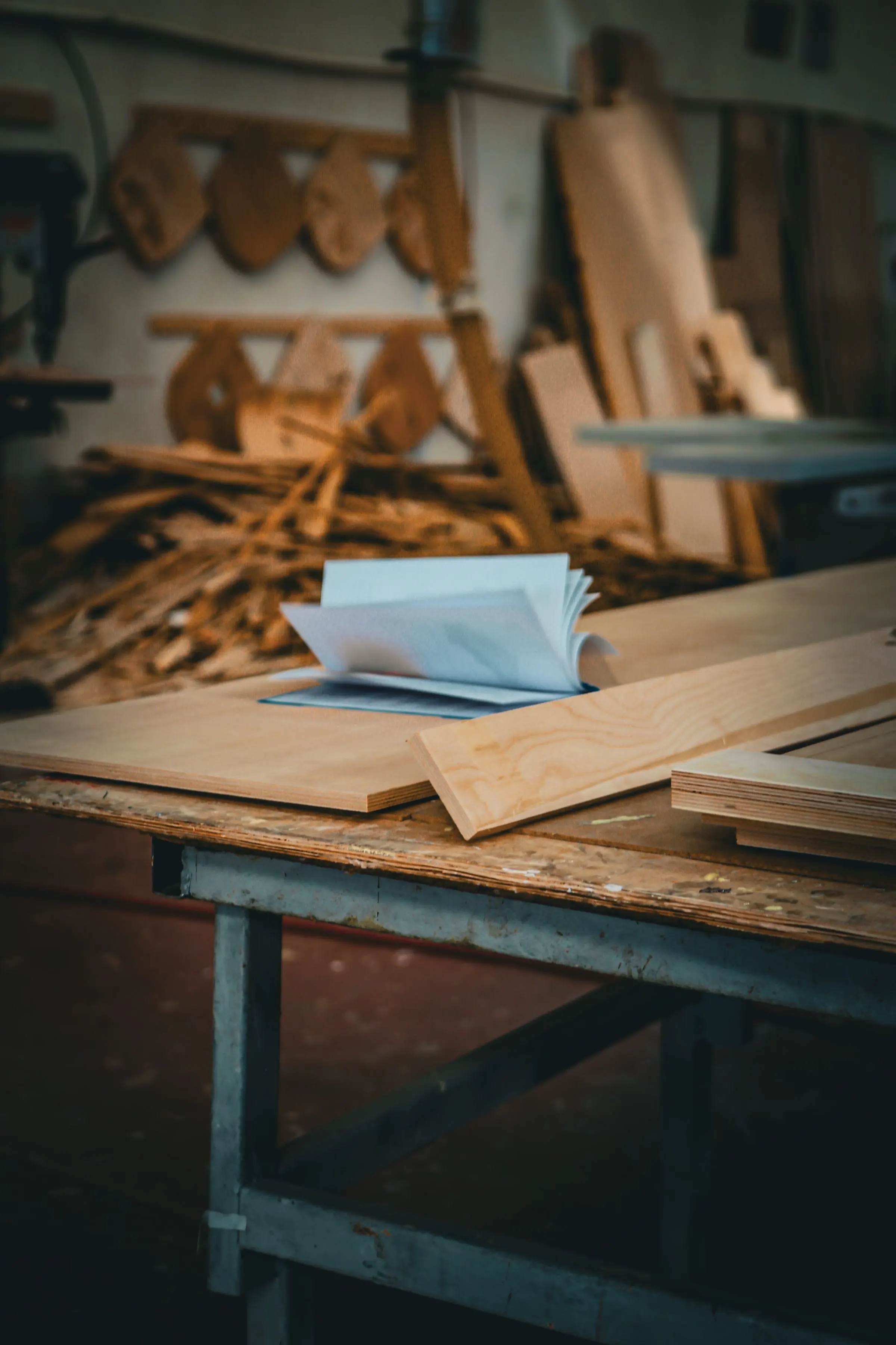 Banco di lavoro con disegni arrotolati e tavole di legno appoggiate