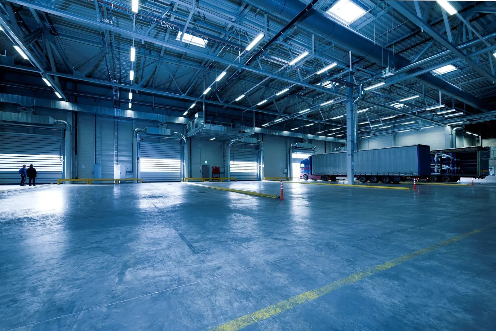 Capannone logistico vuoto in luce blu, con il pavimento lucido