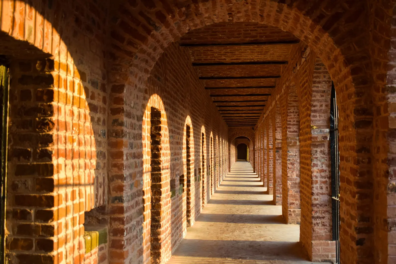 Portico in mattoni con gli archi in fuga e la luce del pomeriggio