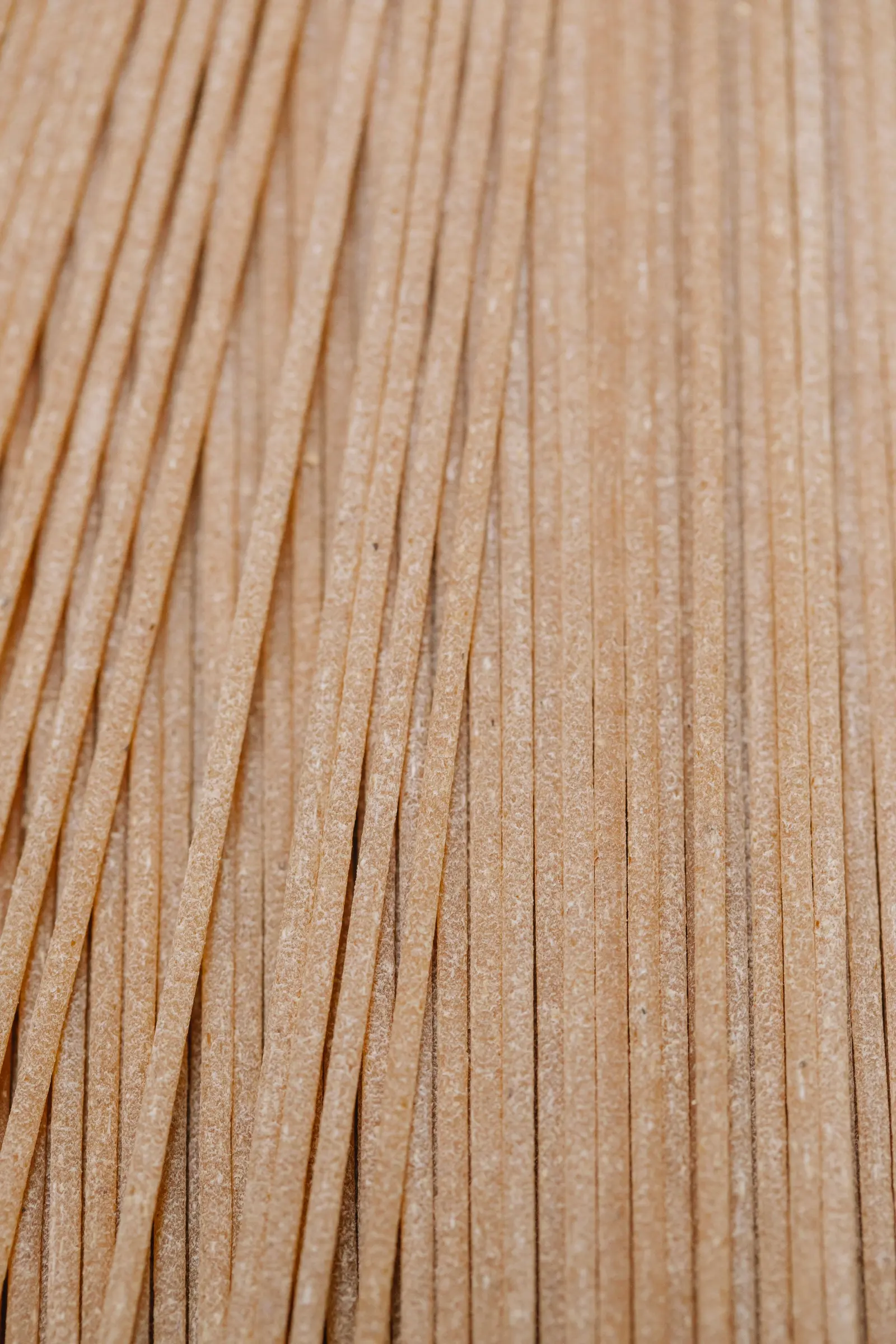 Spaghetti integrali crudi allineati, color nocciola