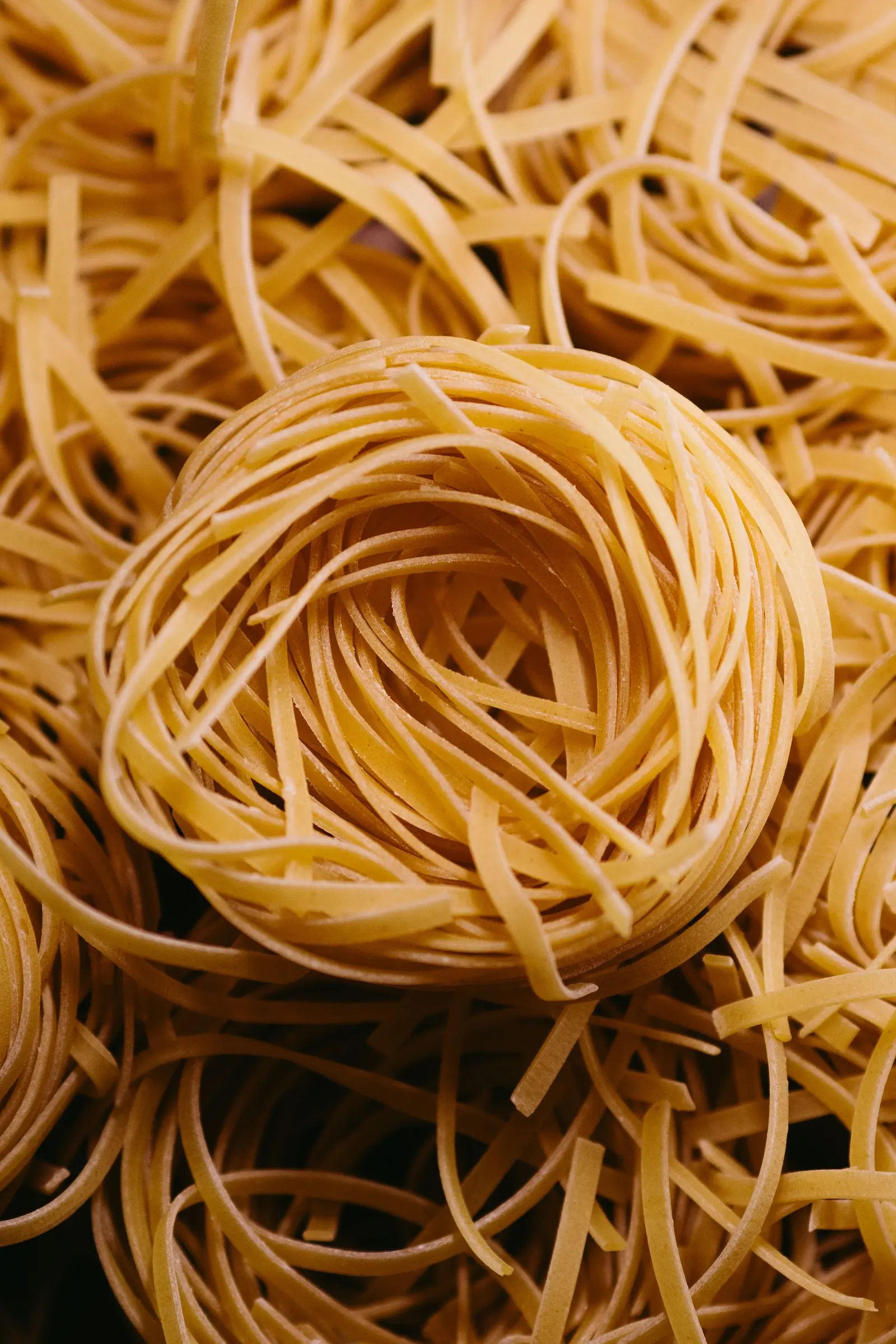 Matassine di pasta lunga secca su fondo scuro
