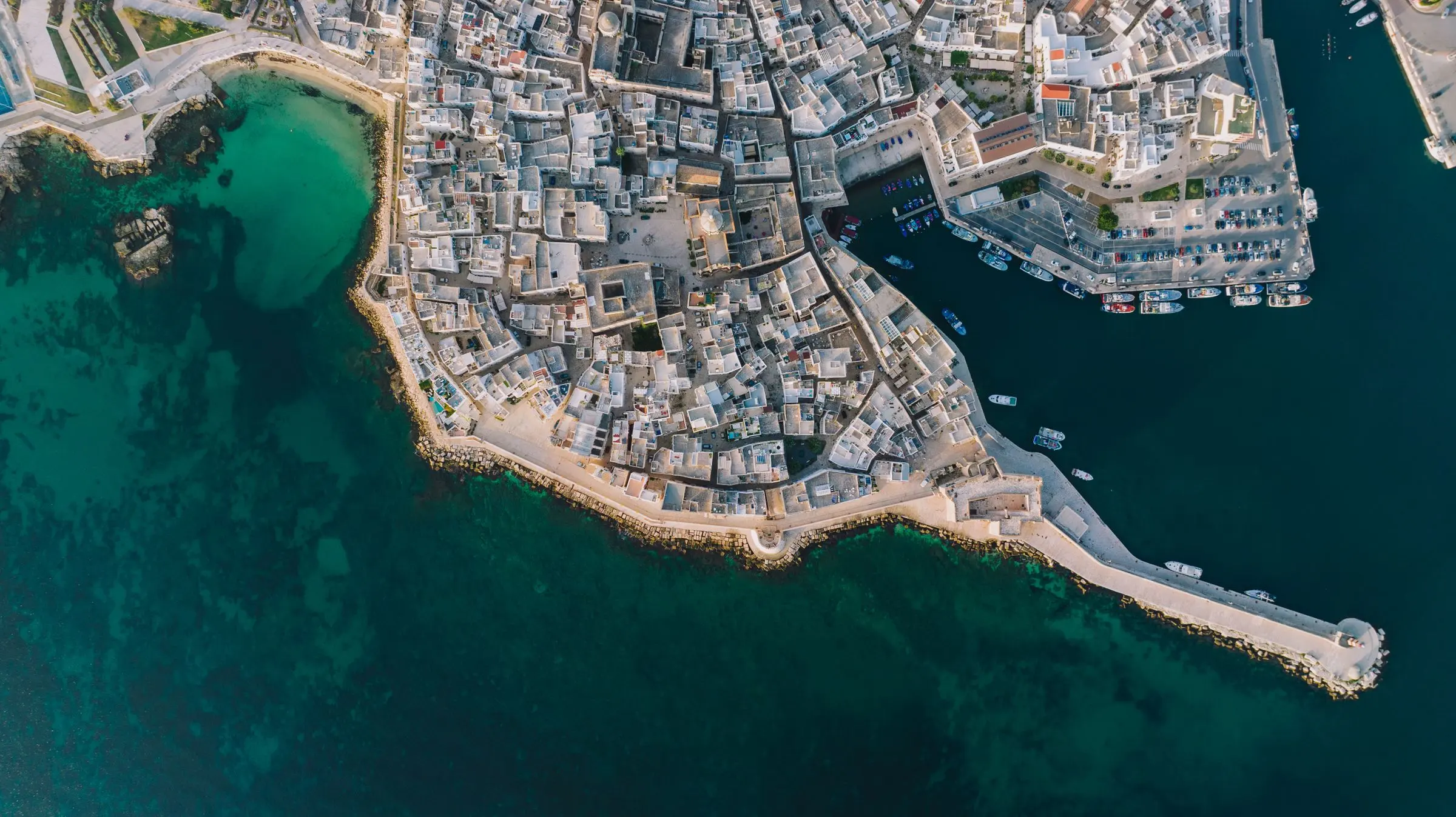 Monopoli vista dall’alto: il centro storico sul mare, il porto antico con le barche e l’acqua turchese della cala