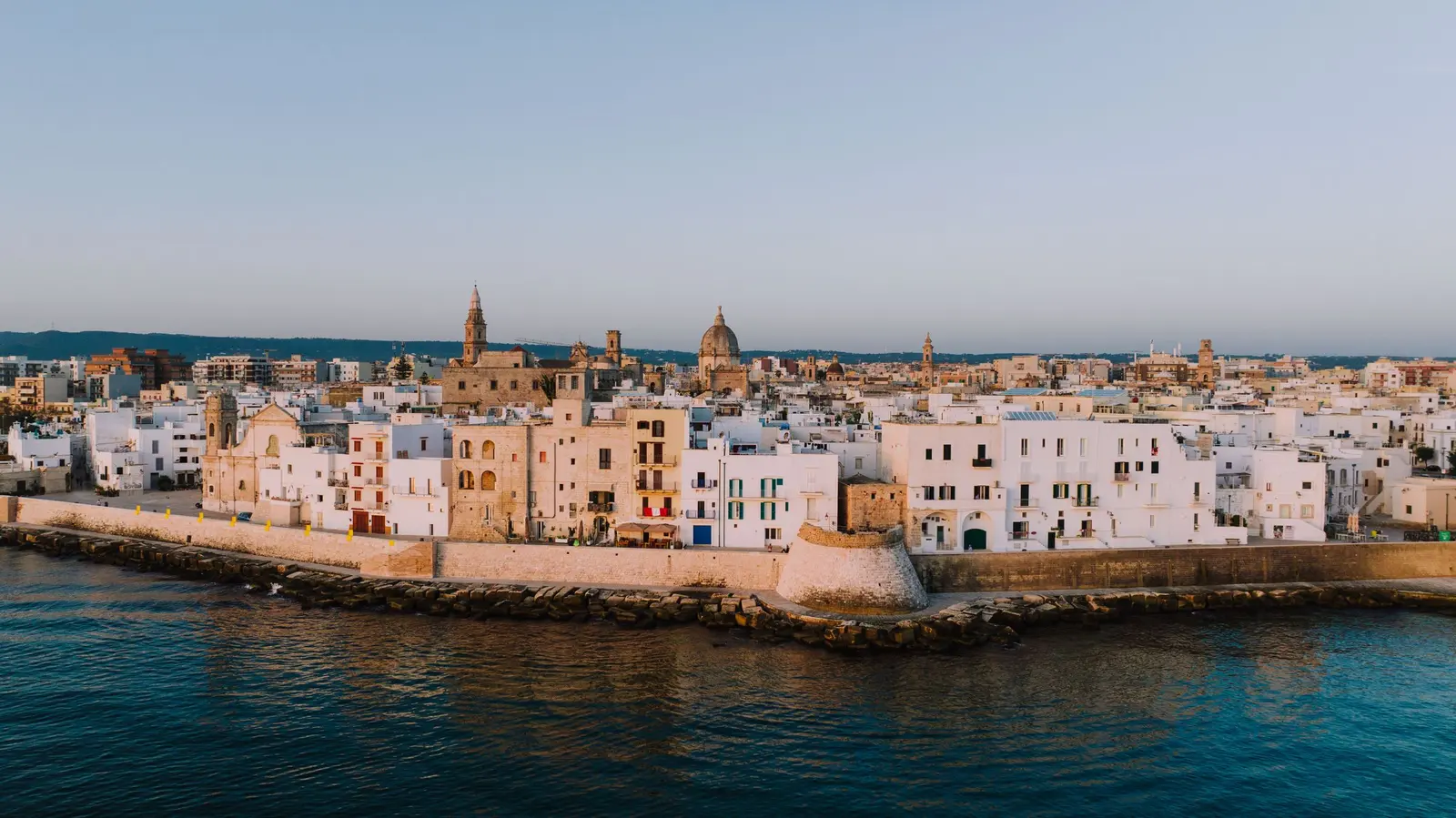 Monopoli vista dal mare all’alba: le mura e le case bianche del lungomare