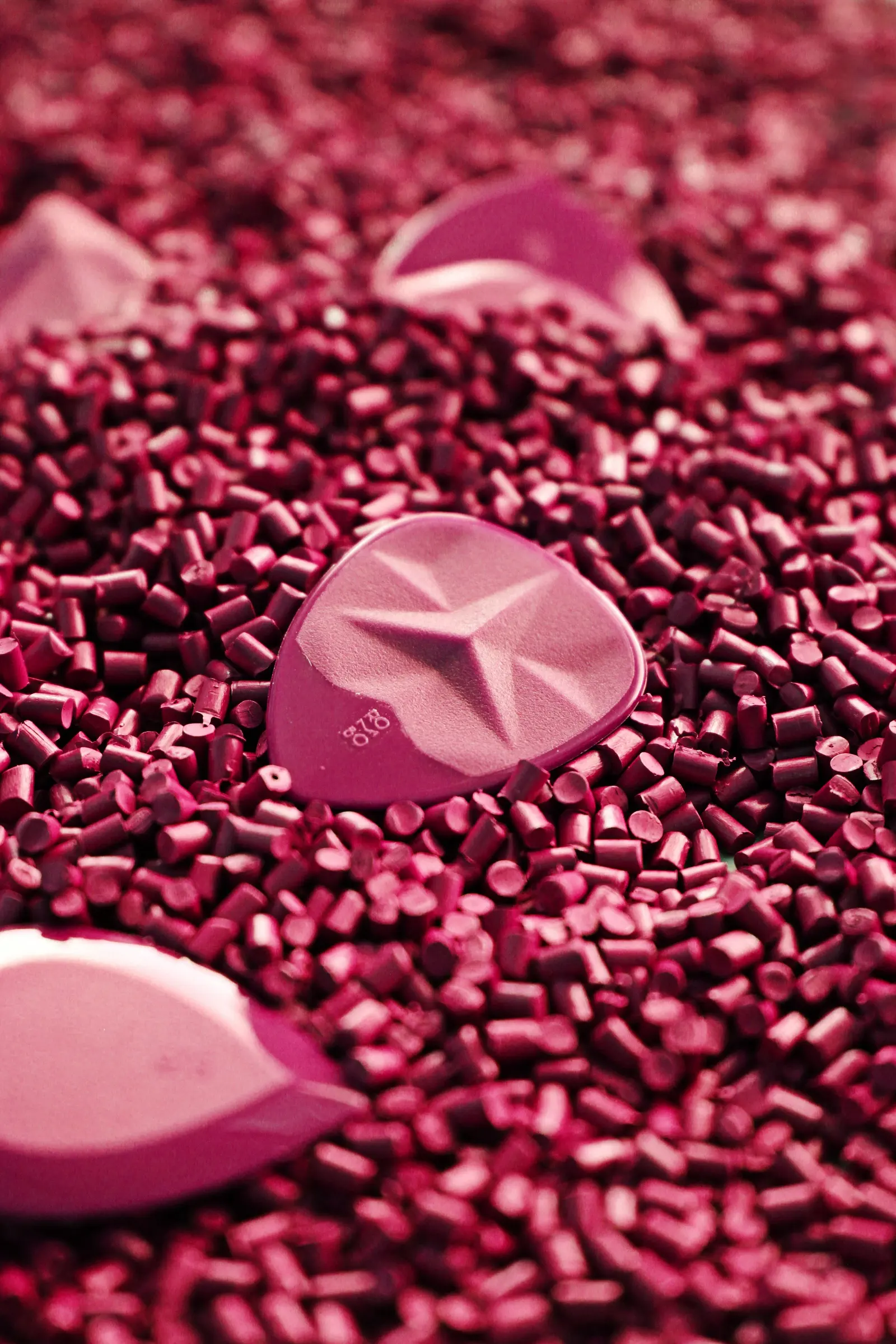 Plettri stampati rosa e lilla appoggiati su granuli magenta