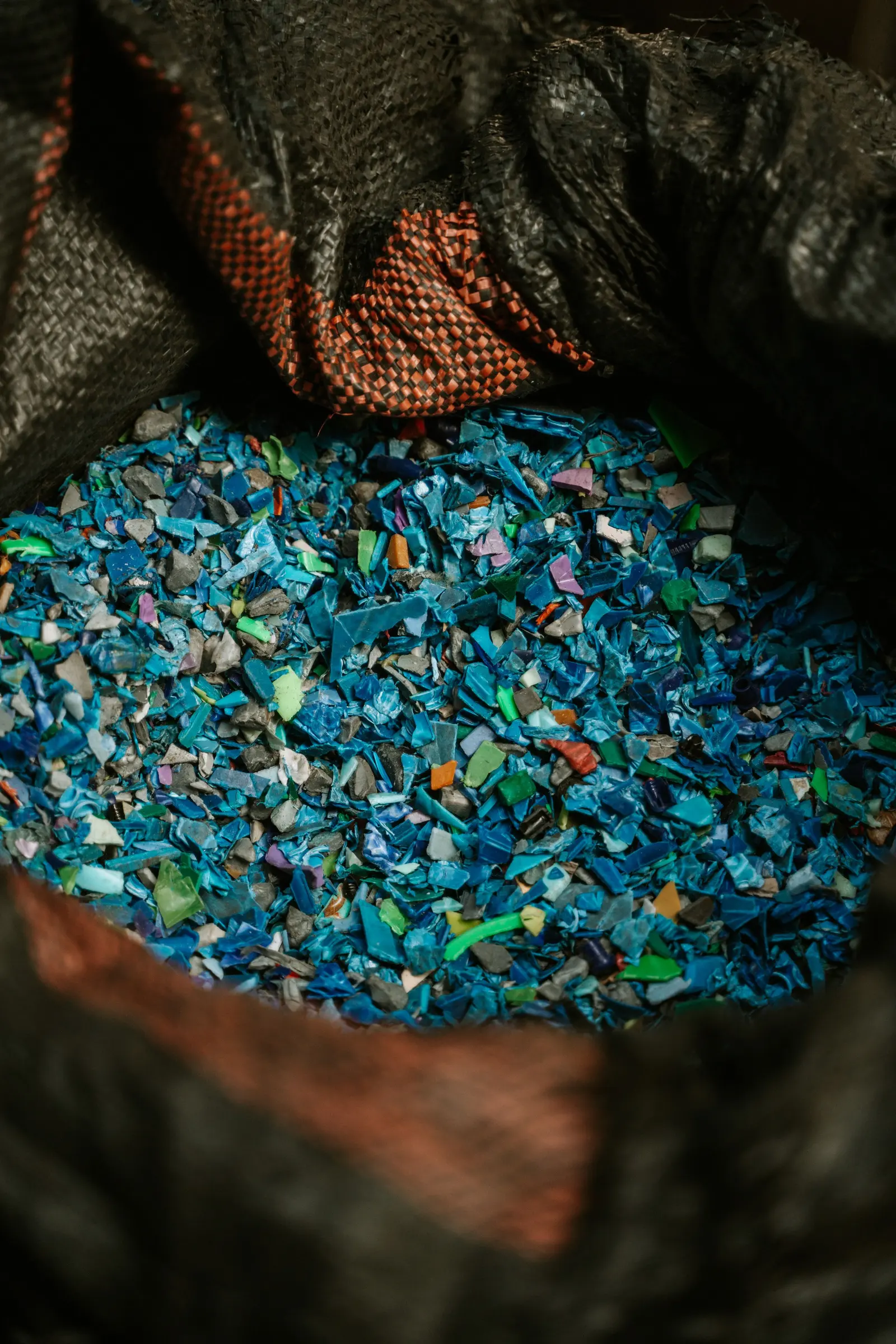 Un sacco pieno di frammenti di plastica macinata in tanti colori