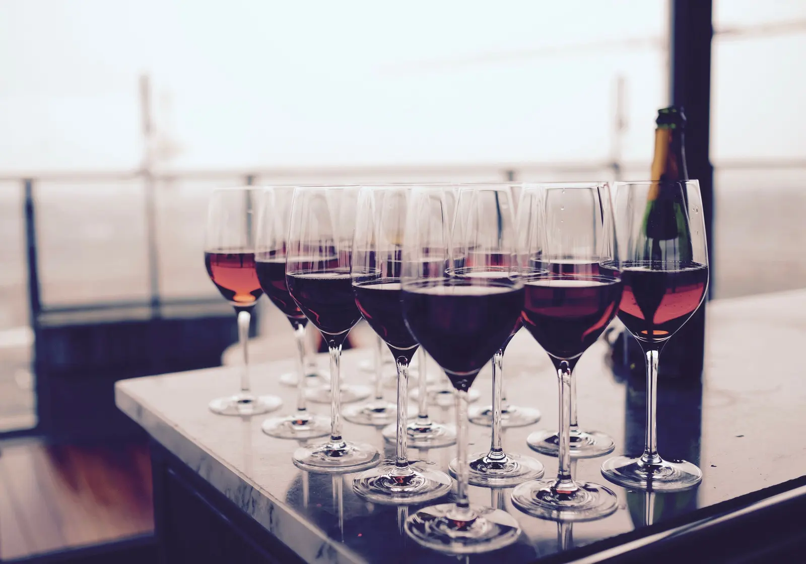 Calici di vino rosso allineati su un tavolo all'aperto
