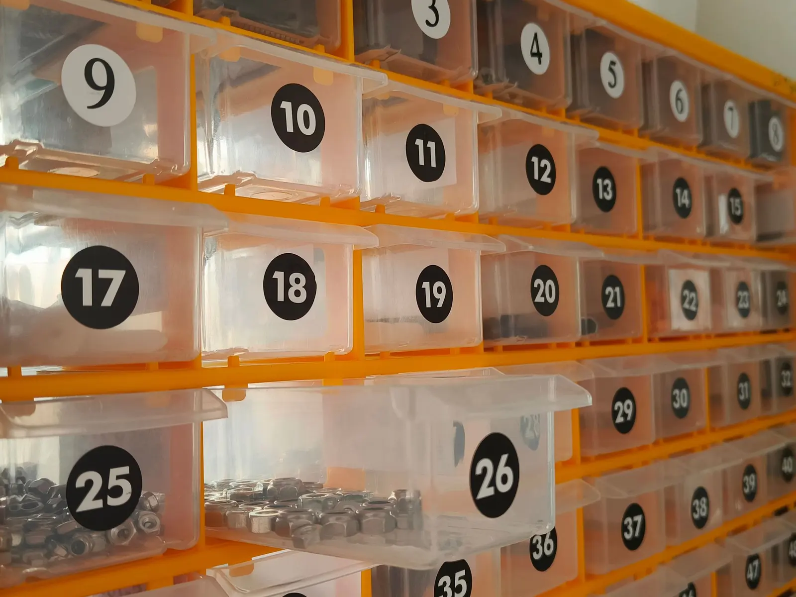 Cassettiere arancioni numerate piene di minuteria