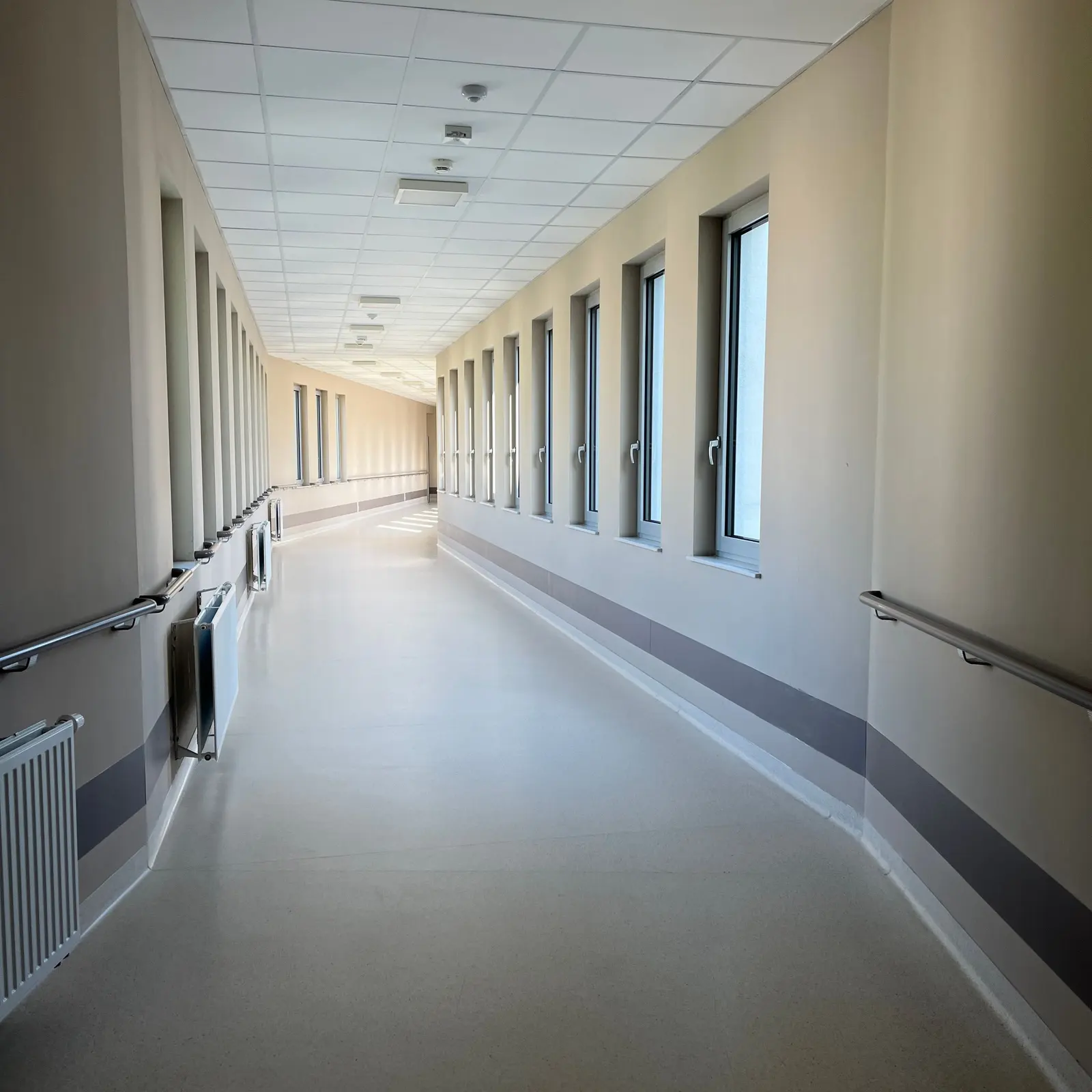 Un corridoio d'ospedale luminoso e vuoto, con le finestre sulla destra