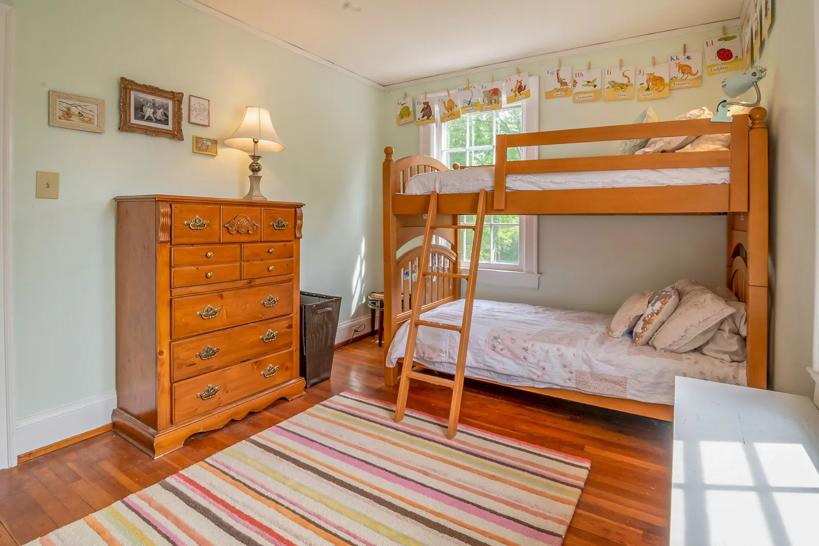 La camera dei bambini con il letto a castello di legno e il tappeto a righe