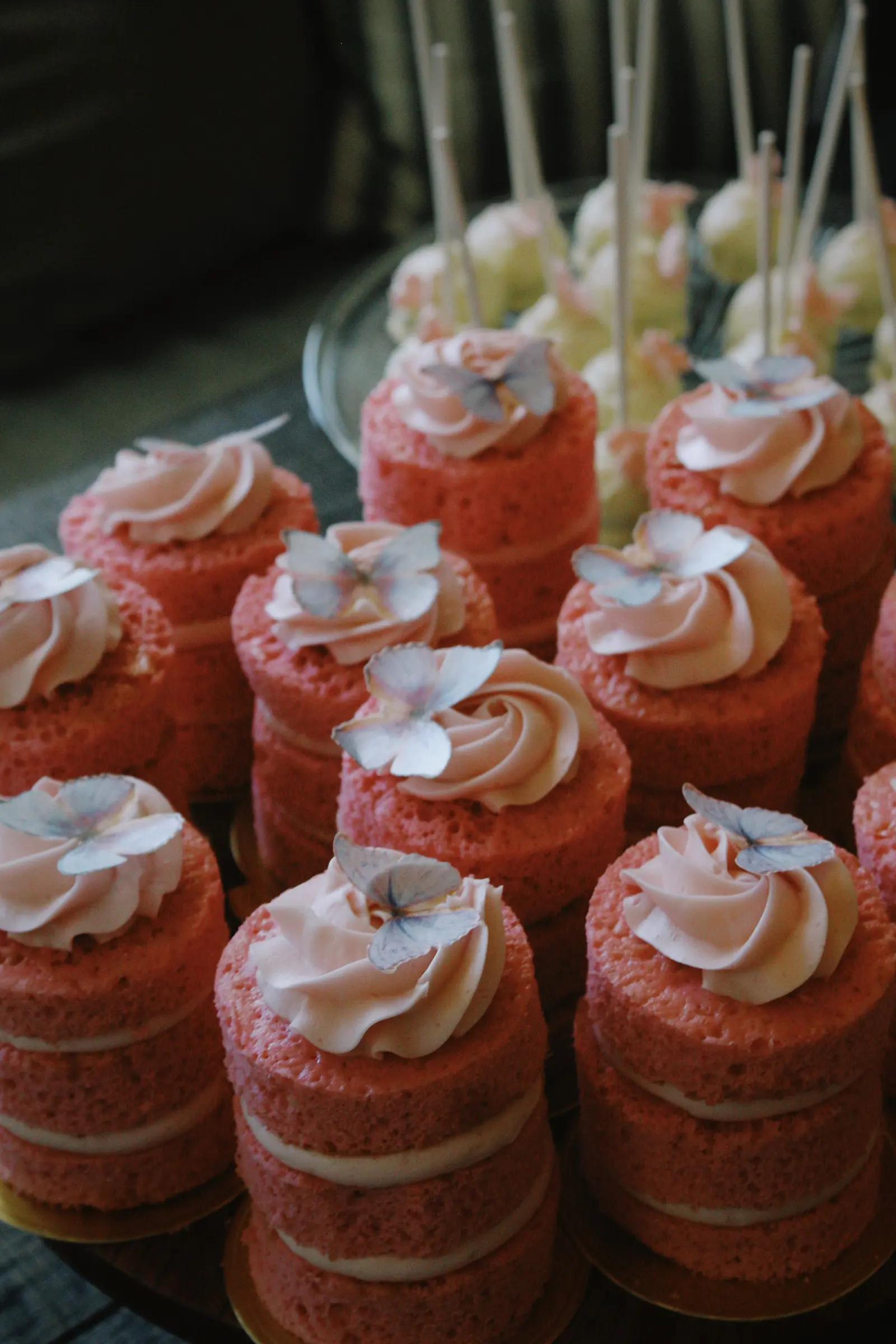 Piccole torte a strati rosa con ciuffi di crema