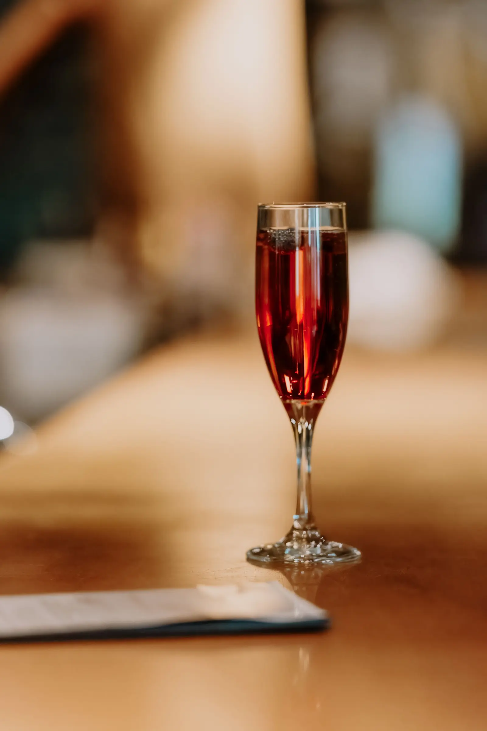 Un calice di lambrusco frizzante sul banco di legno