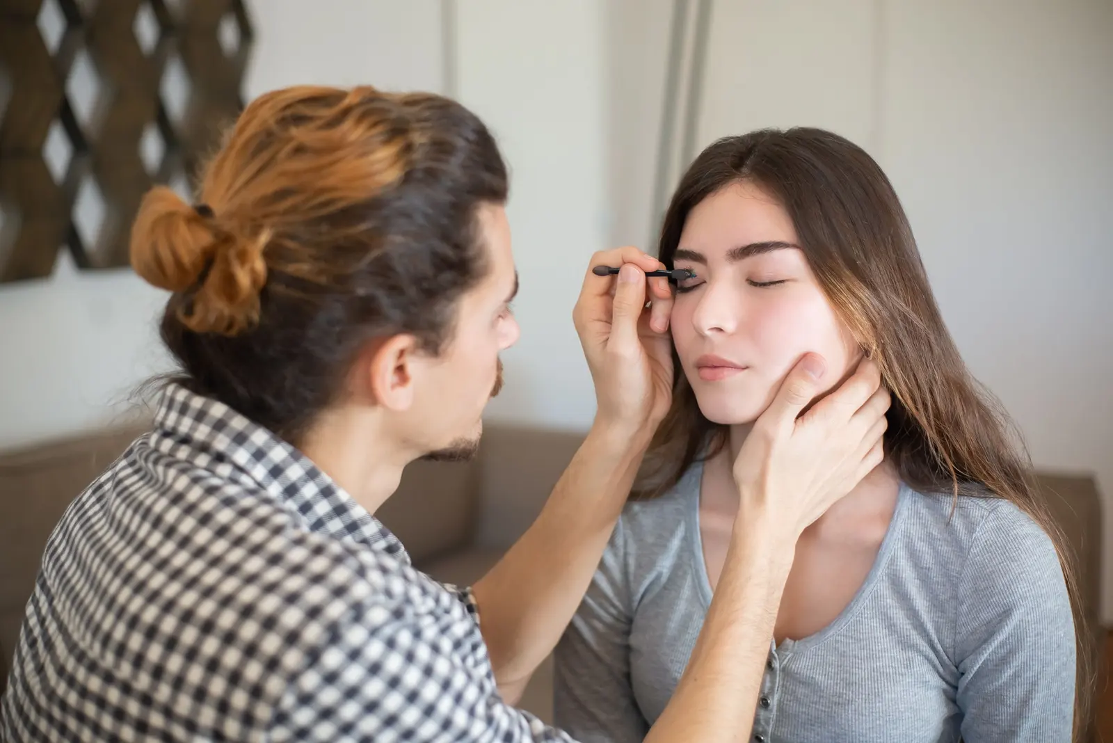 Un truccatore disegna le sopracciglia a una ragazza