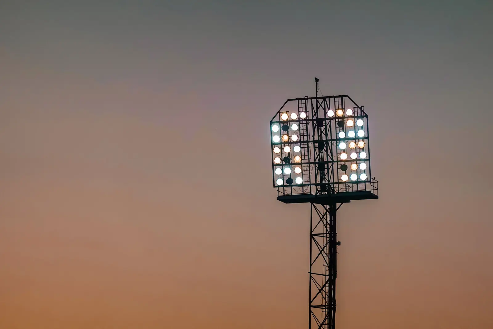 Torre faro accesa contro il cielo del tramonto