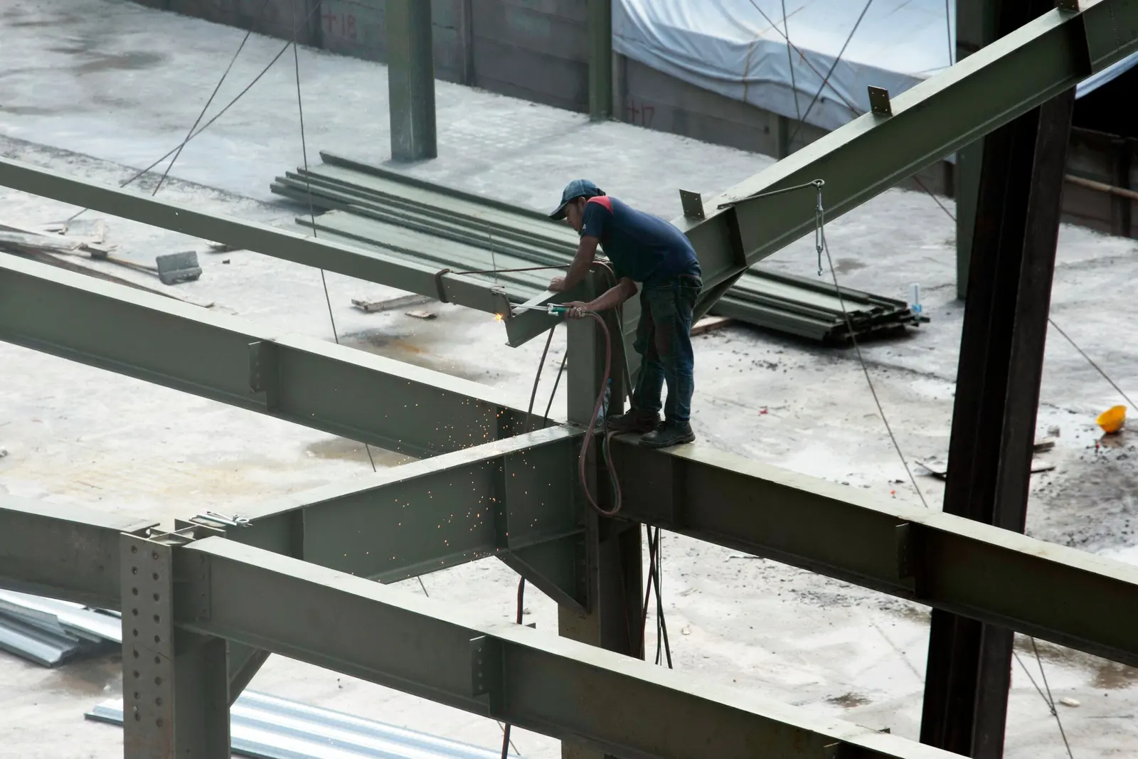 Un operaio salda una trave su una struttura d'acciaio in costruzione