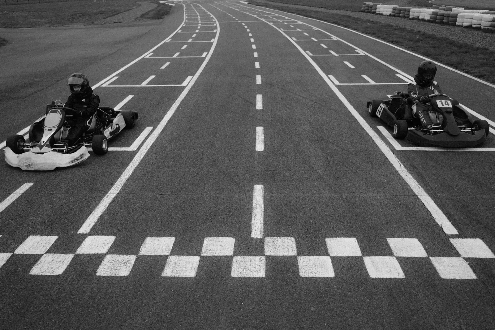 Due kart fermi sulla griglia di partenza, con la linea a scacchi in primo piano