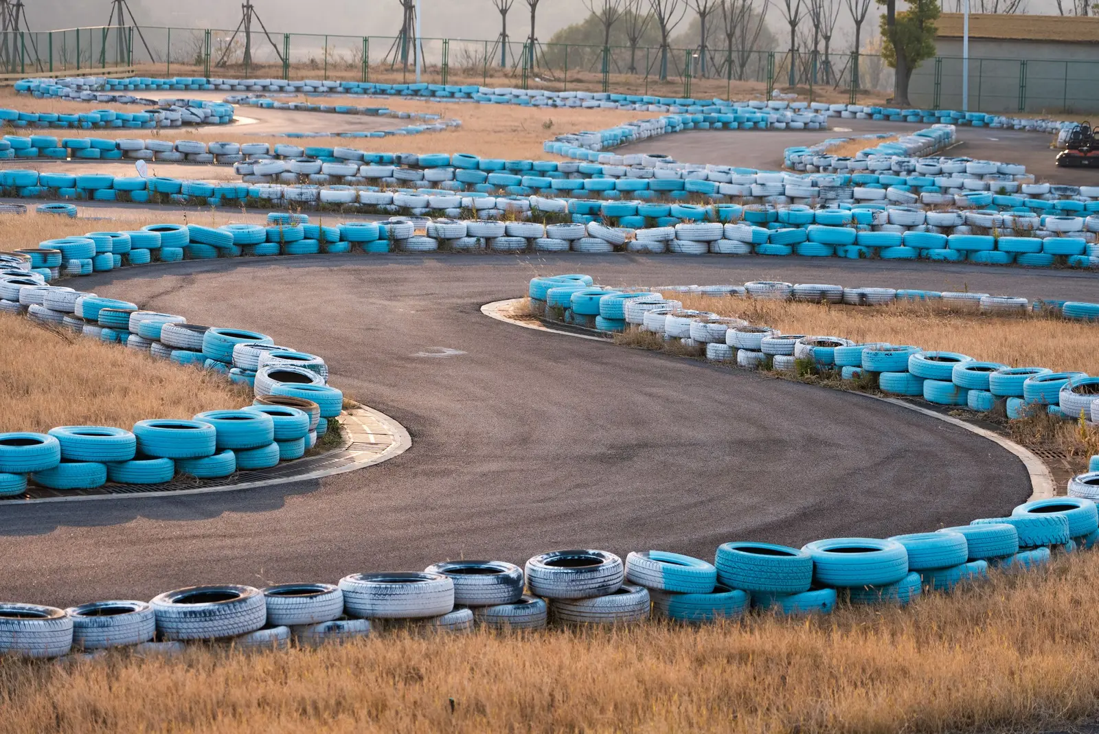Pista da kart vuota con le barriere di gomme bianche e azzurre lungo le curve