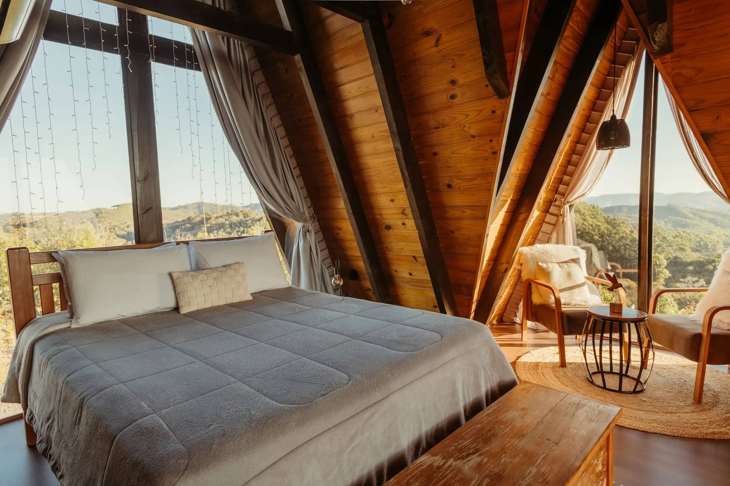 Camera da letto sotto le falde in legno con vetrate sulla valle