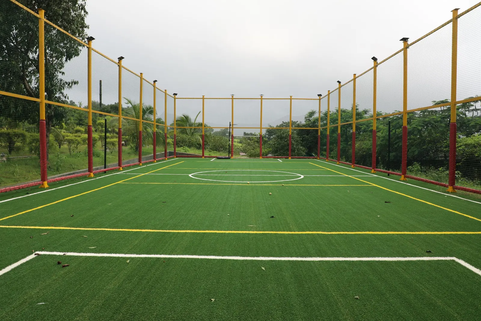 Campo da calcio a 7 in erba sintetica, chiuso da pali e reti gialle