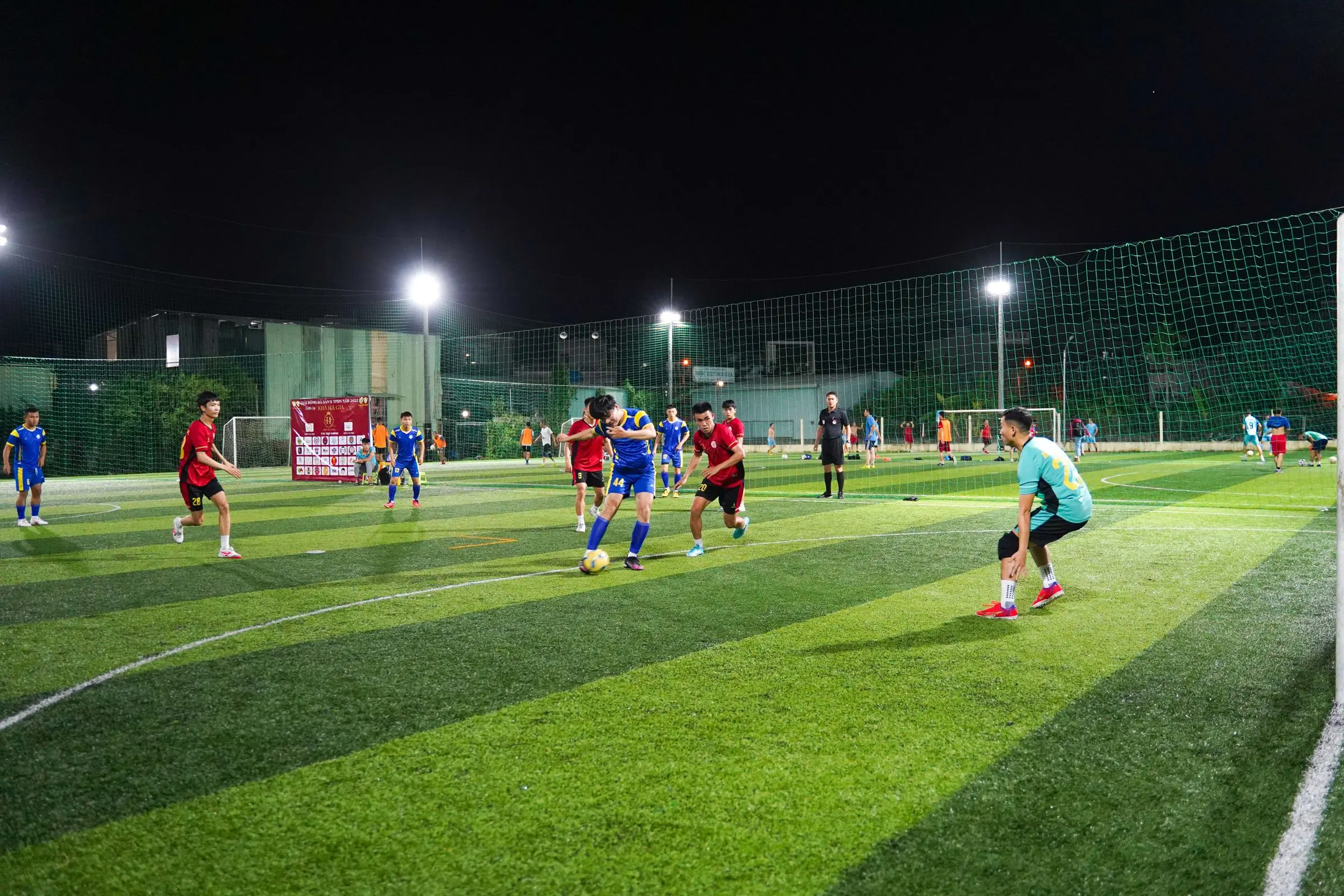 Partita serale di calcio a 5 su un campo in erba sintetica illuminato dai fari