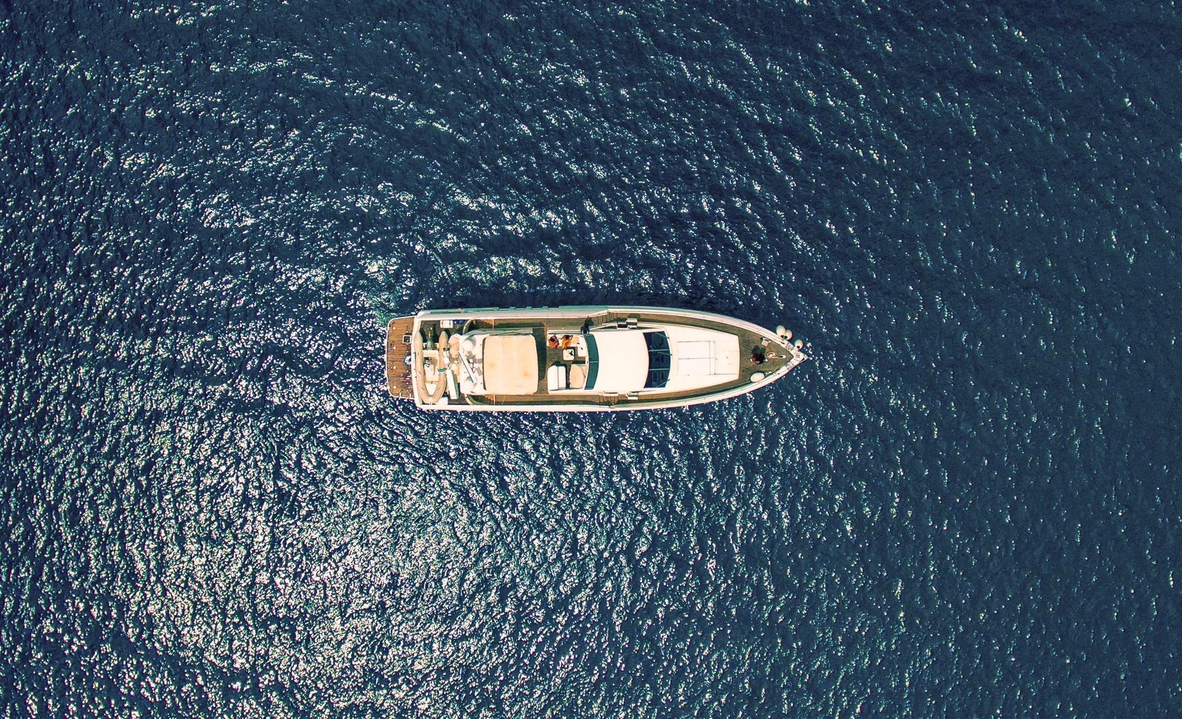 Varea 105 visto dall'alto, alla fonda in mare aperto: coperta in teak, flybridge e tender a poppa