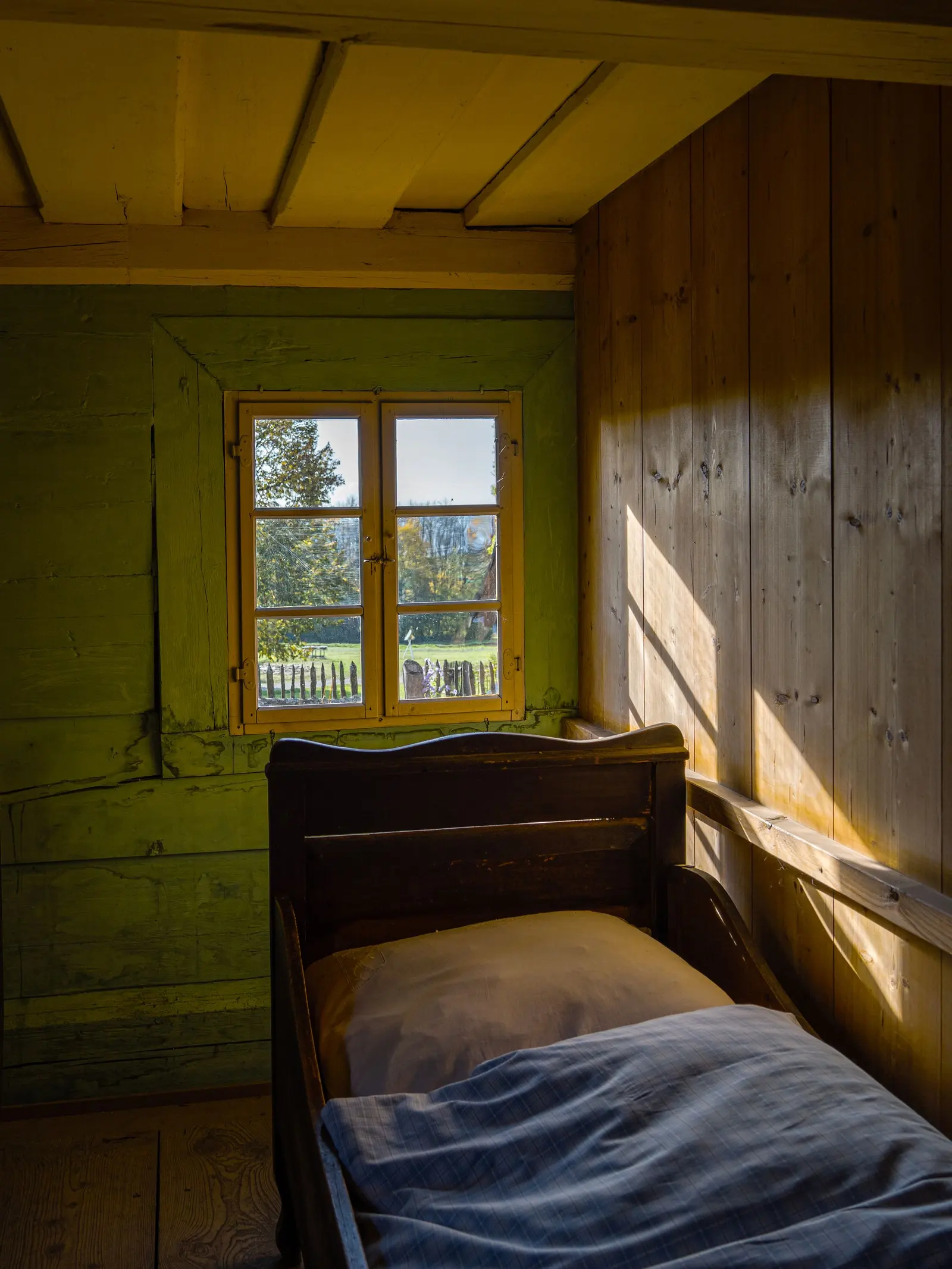 Camera rustica con letto di legno e luce del mattino dalla finestra