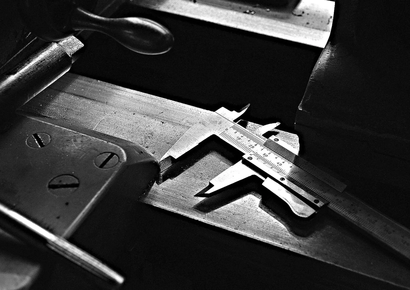 Calibro a corsoio su un banco d'officina, in bianco e nero